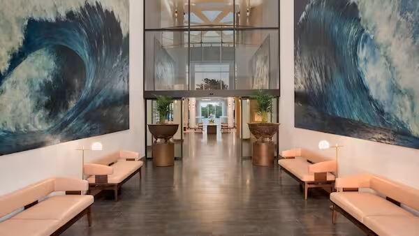 Modern hotel lobby with ocean wave artwork and contemporary seating
